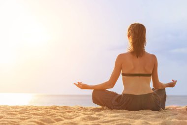 Kadın oyun Yoga ve egzersiz günbatımı, tropikal sahilinde 
