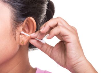 Kadın WHI üzerinde izole pamuk bud stick kullanarak onun kulak Temizleme