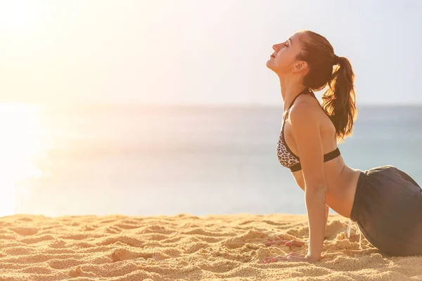 Frau spielt Yoga und Bewegung am tropischen Strand bei Sonnenuntergang — Stockfoto