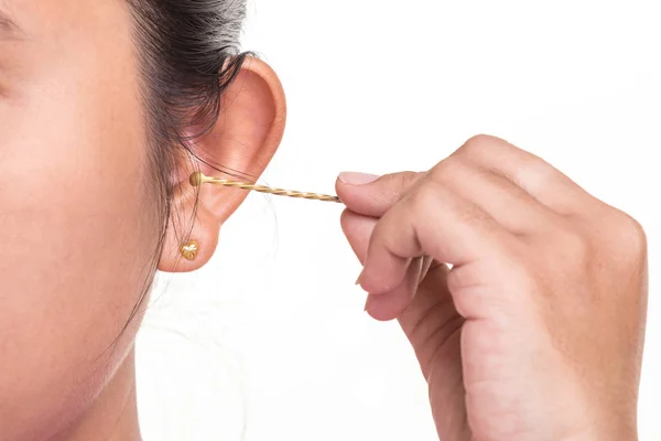 Close up woman cleaning her ear by using metal stick isolated on — Stock Photo, Image
