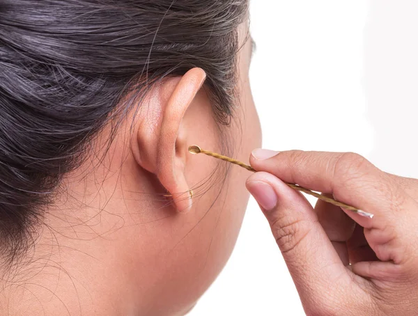 Cerca de la mujer limpiando su oído mediante el uso de palo de metal aislado en —  Fotos de Stock