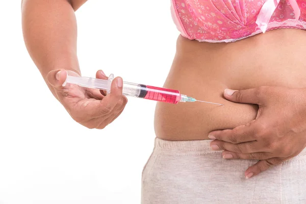 Mujer gorda sosteniendo la jeringa e inyectándose medicina roja en el vientre i — Foto de Stock