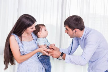 Beyaz çocuk kontrol doktor. Anne bebeğini hos içinde taşımak