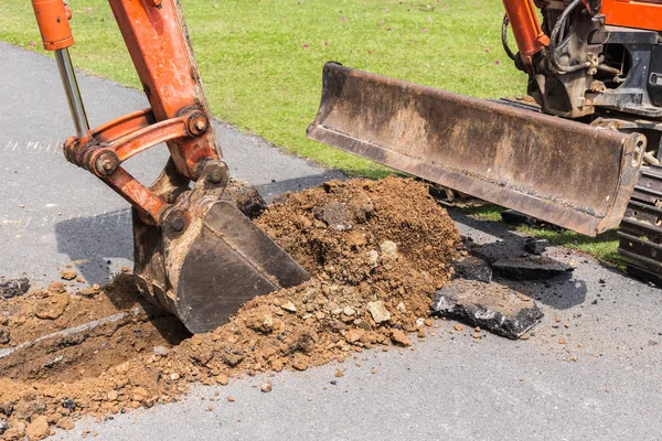 Digger machine fonctionnent pour creuser le sol et réparer la route dans le p — Photo