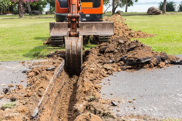 Digger machine fonctionnent pour creuser le sol et réparer la route dans le p — Photo