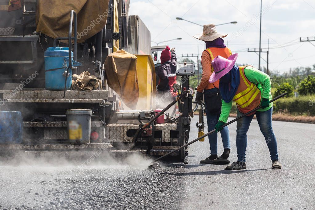 Worker operating the process of building new asphalt road on the