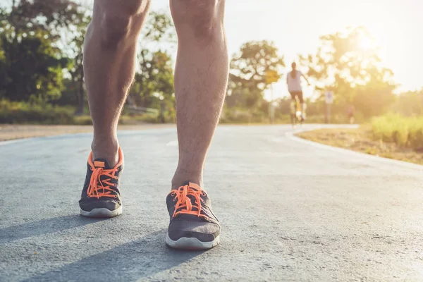 Concepto de bienestar de entrenamiento de hombre: Pies de corredor con zapatilla de deporte — Foto de Stock