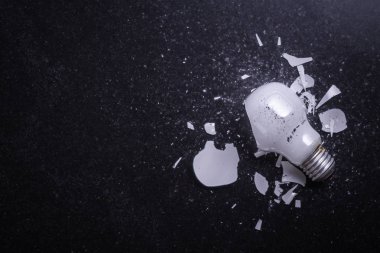 Kırık beyaz ışık ampul kara taş yüzeyi