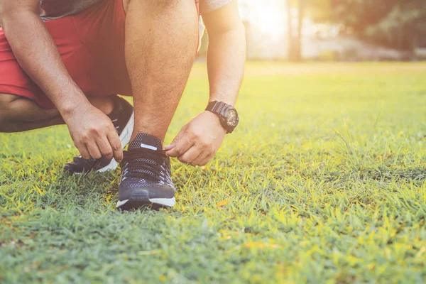 Man tying rope on his sports shoe. Preparing for run in the park — Stock Photo, Image