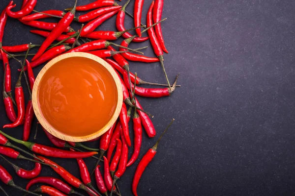 Frisches rotscharfes Chili mit Sauce in Holzschale auf Schwarz — Stockfoto