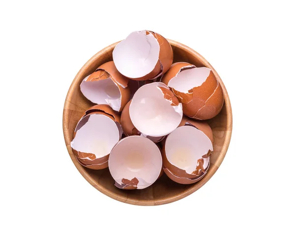 Hromada vaječné skořápky v dřevěné misce. Pohled shora a izolované na bílém — Stock fotografie