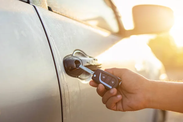 Hand hält ferngesteuerte Autoschlüssel und drückt die Taste öffnen oder verriegeln — Stockfoto