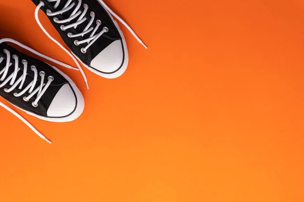 Vista dall'alto nuova scarpa moda nera con corda bianca su carta arancione — Foto Stock