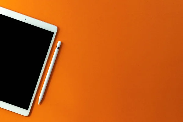 Nowy model czarny ekran tabletka i ołówek na pomarańczowym tle. C — Zdjęcie stockowe
