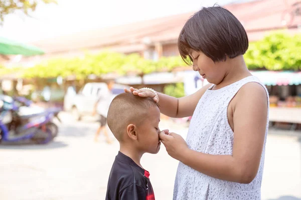 Ung asiatisk pojke gråter och hans gamla syster försöker uppmuntra — Stockfoto