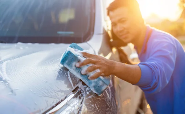 Asiatico uomo utilizzando blu spugna con sapone per lavaggio il auto a outd — Foto Stock