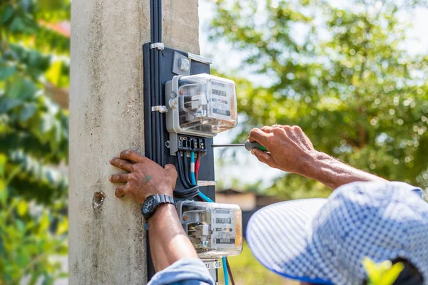 Technician installing electric meter on the pole Stock Photo