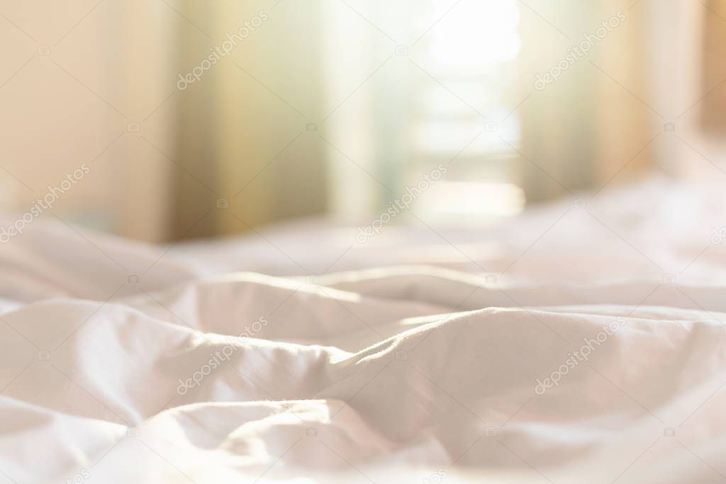 White bedding sheets and pillow in hotel room at morning time wi