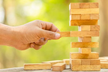 Blok ahşap oyun üzerinde yeşil arka plan bulanık tutan el. İle 