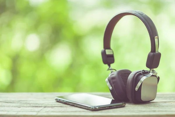 Close New Smartphone Headphone Wooden Table Green Space Nature Blur — Stock Photo, Image