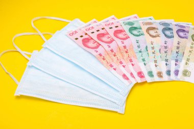 Çin banknotu (Yuan) ve sarı arkaplanda yeni beyaz maske.