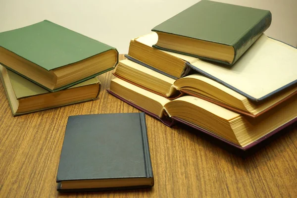 Composition of open and closed books on a brown table-close-up.