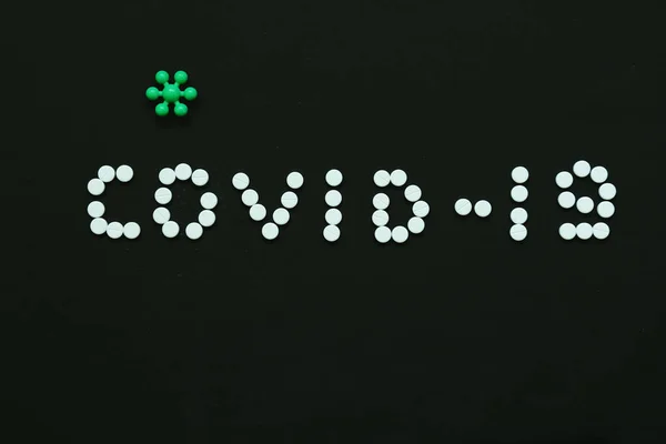 Coronavirus COVID-19 'un yeni adı. Coronovirüs COVID-19 'un sebep olduğu viral zatürre için tıbbi bir tedavi. Koyu arkaplanda koronovirüs tedavisi için renkli haplar