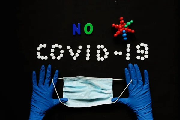 Doktorların ellerinde koruyucu eldivenlerle tıbbi maske. Mavi arka plan. Coronavirus konsepti. Dünyada salgın hastalık.