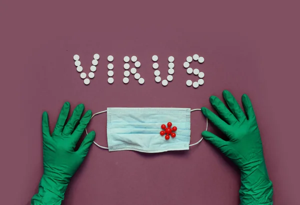 Beyaz haplardan VIRUS yazıtları, koruyucu eldivenler, tıbbi maske.