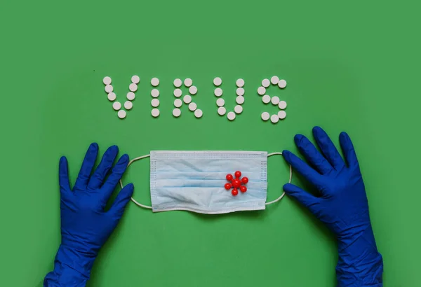 Beyaz haplardan VIRUS yazıtları, koruyucu eldivenler, tıbbi maske.