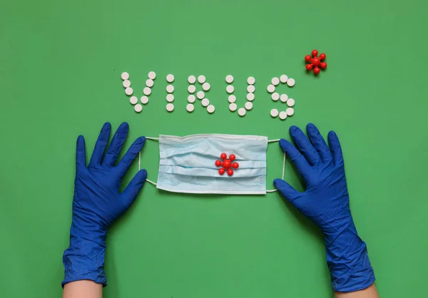 Beyaz haplardan VIRUS yazıtları, koruyucu eldivenler, tıbbi maske.