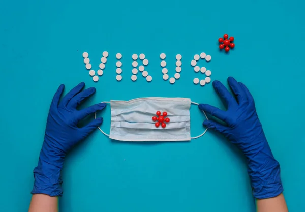 Beyaz haplardan VIRUS yazıtları, koruyucu eldivenler, tıbbi maske.