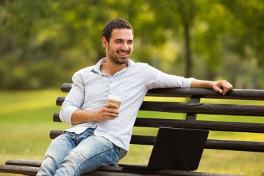 İşadamı kahve içme ve dizüstü bilgisayar kullanarak