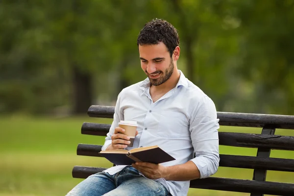 Bir kitap okuma ve kahve içmek işadamı — Stok fotoğraf