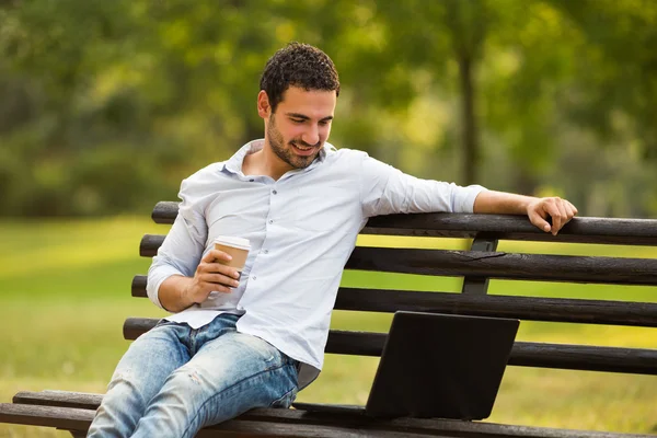 Geschäftsmann trinkt Kaffee und nutzt Laptop — Stockfoto