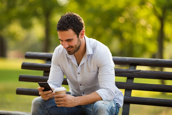 Empresario está bebiendo café y usando el teléfono — Foto de Stock