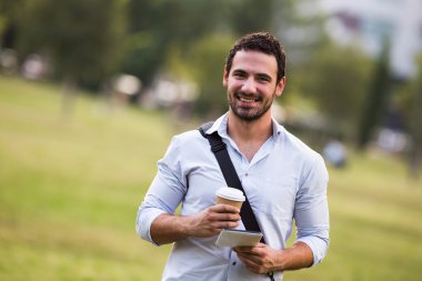 Kahve içme ve dijital tablet kullanarak iş adamı 