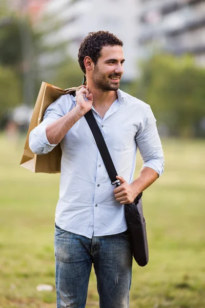Geschäftsmann mit Einkaufstüten steht im Park — Stockfoto