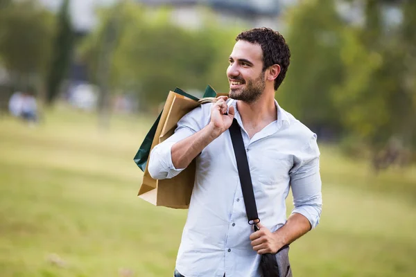 Geschäftsmann mit Einkaufstüten steht im Park — Stockfoto