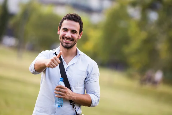 Geschäftsmann trinkt Wasser und zeigt Daumen hoch — Stockfoto