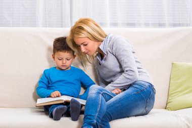 Anne ve oğul birlikte kitap okuyorlar..