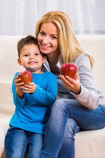 Mother and son eating apple Stock Picture
