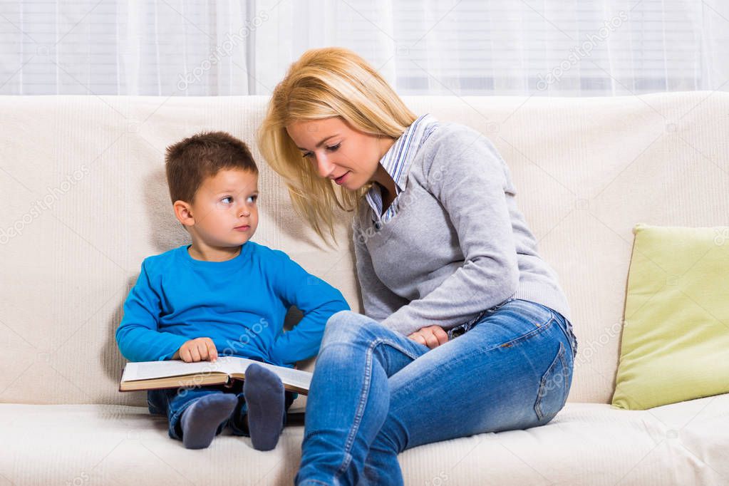 Mother and son  reading book together.