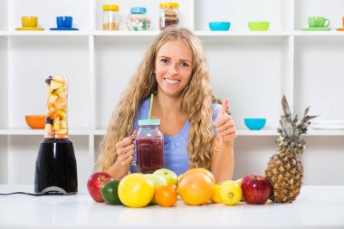 Smoothies yapma ve başparmak gösterilmesini güzel kız