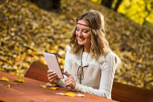 Boho meisje met digitale tablet in het park. — Stockfoto