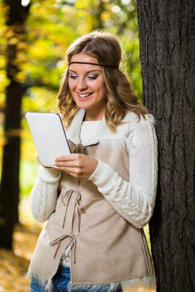 Boho meisje met digitale tablet in het park. — Stockfoto