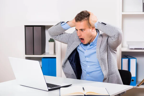 Businessman  looking at laptop in panic — Stock Photo, Image