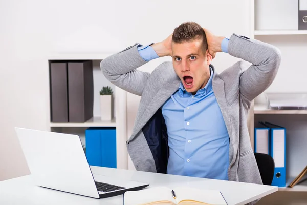 Businessman sitting at office in panic — Stock Photo, Image