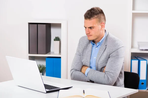 Homem de negócios irritado olhando para seu laptop — Fotografia de Stock
