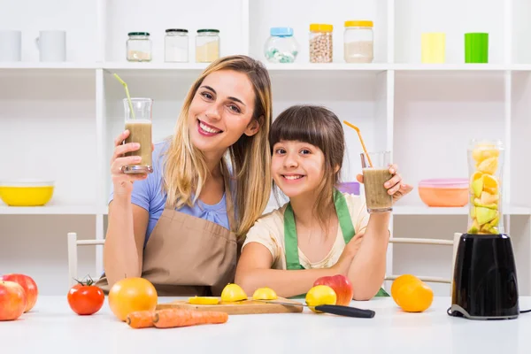 Mutter und Tochter machen und trinken Smoothies — Stockfoto